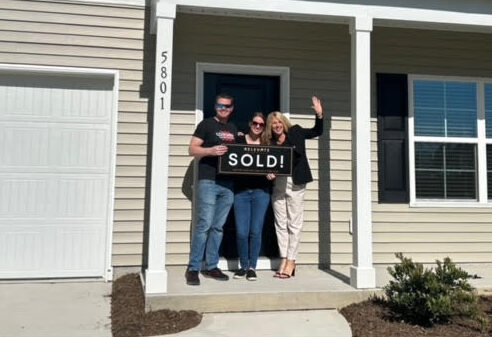 Two satisfied homebuyers in front of home